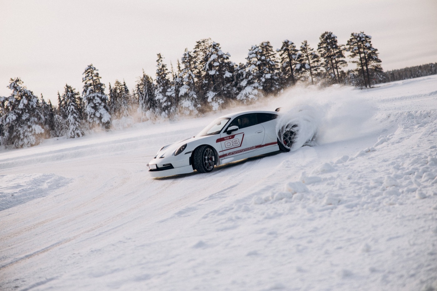 Porsche в заносе, снежный веер из-под колёс
